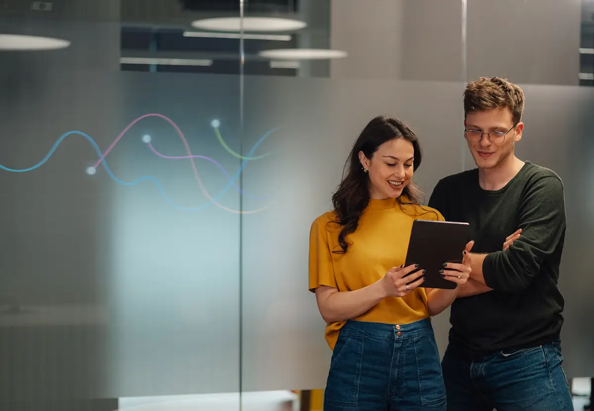 Two people looking at a tablet screen.